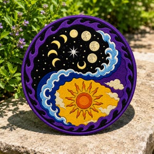 May include: A circular embroidered patch featuring a yin-yang design. One side is black with yellow moon phases, a white star, and blue waves. The other side is yellow with a central sun, orange center, and white clouds, framed by purple flames.