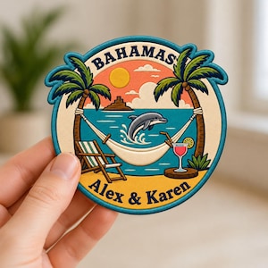May include: A circular embroidered patch featuring a tropical Bahamas scene with two palm trees, a hammock, a jumping dolphin, a beach chair, and a cocktail. The text BAHAMAS is at the top and ALEX & KAREN is at the bottom in dark blue lettering.