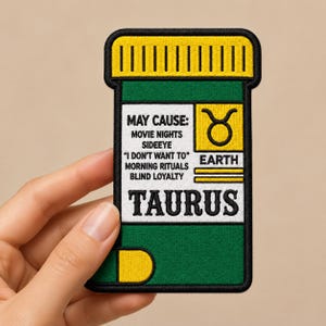 May include: A rectangular embroidered patch shaped like a medicine bottle with a green body and yellow cap. The white label features the text MAY CAUSE: MOVIE NIGHTS, SIDEEYE, I DON'T WANT TO, MORNING RITUALS, BLIND LOYALTY, TAURUS, EARTH, and a Taurus symbol.