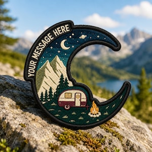 May include: A crescent moon-shaped embroidered patch featuring a night sky with a crescent moon, stars, and a planet. The design includes mountains, pine trees, a vintage camper, and a campfire. The text "YOUR MESSAGE HERE" is stitched along the curve.