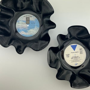 May include: Two black vinyl record bowls with labels. The top bowl has a label for "Look Out For My Love" by "Brenda Russell". The bottom bowl has a label for "Knocked Out" by "Paula Abdul".