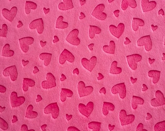 May include: A pink fabric background with a repeating pattern of embossed hearts.