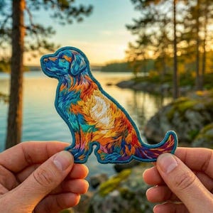 May include: A fabric patch shaped like a sitting dog, featuring a vibrant, multi-colored design with shades of blue, orange, yellow, and red. The embroidered artwork displays a detailed fur texture with a dark blue border outlining the silhouette.