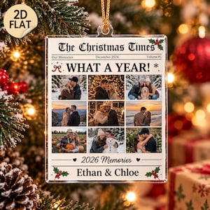 Puede incluir: Un adorno navideño rectangular de acrílico transparente con un diseño de periódico titulado The Christmas Times. Muestra nueve espacios para fotos, el texto WHAT A YEAR!, 2026 Memories y los nombres Ethan & Chloe con detalles de acebo.