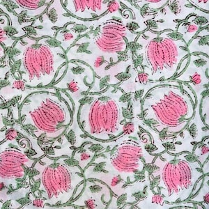 May include: White fabric with a repeating pattern of pink flowers and green vines. The flowers are stylized with detailed petals, and the vines have small leaves. The design is printed on a white background, creating a floral textile.