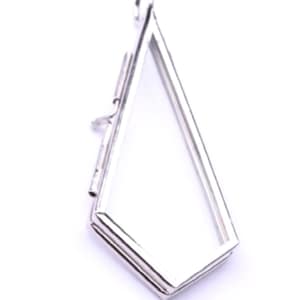 May include: A silver-toned metal photo locket with a diamond-shaped opening. The locket has a hinged opening and a loop at the top for attaching to a chain.