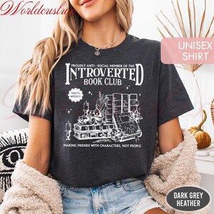 May include: Dark grey heather unisex shirt with the text "INTROVERTED BOOK CLUB" and a graphic of books, candles, and plants. The shirt reads "MAKING FRIENDS WITH CHARACTERS, NOT PEOPLE".