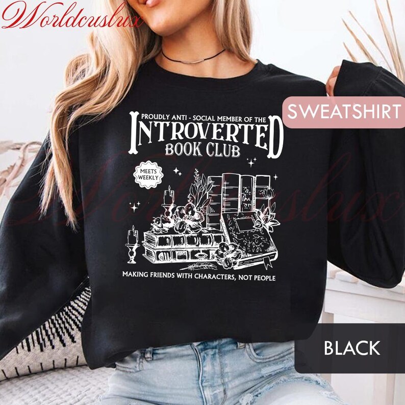 May include: Black sweatshirt with white graphic text: "PROUDLY ANTI-SOCIAL MEMBER OF THE INTROVERTED BOOK CLUB." The design includes books, candles, and the phrase "MAKING FRIENDS WITH CHARACTERS, NOT PEOPLE."