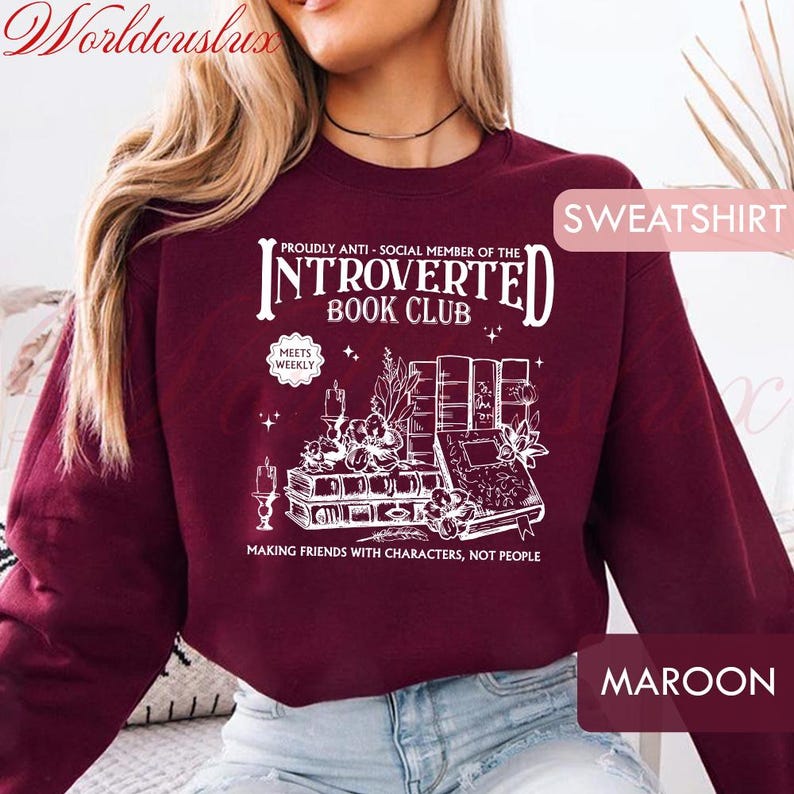 May include: Maroon sweatshirt with a white graphic that reads "Proudly Anti-Social Member of the Introverted Book Club." The design includes illustrations of books, flowers, and candles. The text "Making Friends With Characters, Not People" is also included.