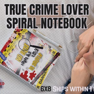 May include: Spiral notebook with the text "TRUE CRIME LOVER SPIRAL NOTEBOOK". The notebook has a spiral binding and features crime scene tape and blood splatter designs. A pen with white polka dots and a magnifying glass are also visible.