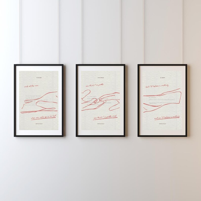 May include: Three framed art prints with black frames. Each print features a minimalist red line drawing and text on a cream background. The prints are hung on a white wall. The text includes phrases like "smile of the man" and "can think I'm pretty".
