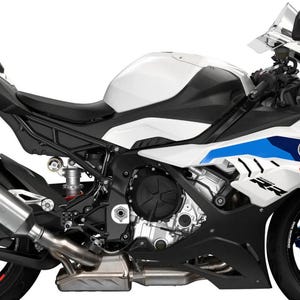 Könnte beinhalten: Ein weißes, schwarzes und blaues BMW S1000RR Motorrad. Das Sportmotorrad hat einen weißen Kraftstofftank, einen schwarzen Sitz und blaue und rote Akzente. Die Räder haben rote und blaue Zierleisten. Das Motorrad hat einen silbernen Auspuff.