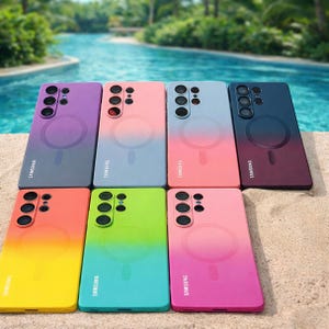 May include: A collection of colorful Samsung phone cases with a gradient design. The cases are in various colors, including purple, pink, blue, green, and yellow. Each case has a circular design on the back and the Samsung logo.