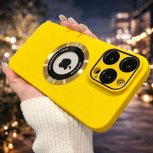 Op de afbeelding: Felge gele telefoonhoes met een cirkelvormig metalen accent en een cameramodule. Het accent heeft de tekst "quality makes the future" en "good luck". De hoes heeft een gladde textuur en een beschermend ontwerp.
