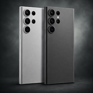 May include: Two smartphones, one silver and one black, are displayed side-by-side. Each phone has a rectangular shape with rounded corners and multiple camera lenses on the back. The silver phone is on the left, and the black phone is on the right.