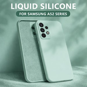 May include: Two light green silicone phone cases for the Samsung A52 series. The cases are shown stacked, with the front case displaying the camera array. The text "LIQUID SILICONE" and "FOR SAMSUNG A52 SERIES" is visible at the top.