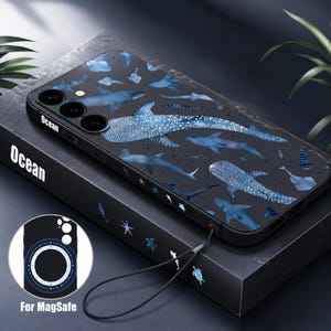May include: A black smartphone case featuring a pattern of blue whale sharks, rays, and sea turtles. The side of the case is printed with the word Ocean. A circular inset shows the back of the case with a magnetic ring and the text For MagSafe.