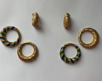 May include: Gold-toned jewelry set featuring two pairs of earrings and two rings. The earrings and one ring have a textured, twisted design. The other ring has blue and green enamel stripes. The jewelry is displayed on a white surface.