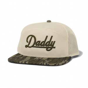 May include: A beige and khaki baseball cap with the word "Daddy" embroidered in green script. The brim features a camouflage pattern, and the back is mesh.