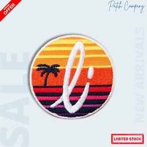 May include: Round patch with a sunset design in orange, yellow, and purple hues. A white "li" script is overlaid on the sunset, with a palm tree silhouette. The patch has a white border and the text "LIMITED STOCK".