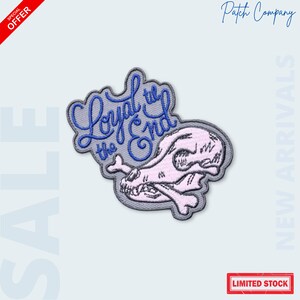 May include: Embroidered patch featuring a pink dog skull and crossbones design with the text "Loyal to the End" in blue script. The patch has a gray border and is labeled "Patch Company".