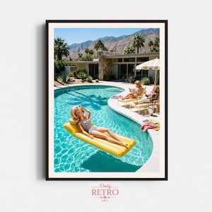 May include: A framed art print depicting a sunny outdoor scene with a turquoise swimming pool, a yellow inflatable raft, and three blonde dolls. One doll floats on the raft in a black and white chequered swimsuit, while two others lounge on chairs.
