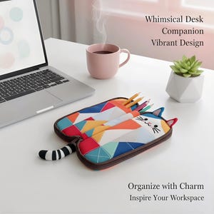 May include: A colorful cat-shaped pencil case with a geometric design, open to reveal pencils. The case is on a white desk next to a laptop, a pink mug, and a small succulent plant. Text reads: Whimsical Desk Companion, Vibrant Design, Organize with Charm, Inspire Your Workspace.