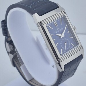 Pu&ograve; includere: Un orologio da polso rettangolare con quadrante blu e cassa color argento. L'orologio ha un cinturino in pelle blu scuro. Il quadrante dell'orologio presenta il marchio "Jaeger-LeCoultre".