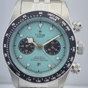 Op de afbeelding: Roestvrijstalen polshorloge met een lichtblauwe wijzerplaat en zwarte lunette. Het horloge heeft een chronograaffunctie met twee sub-wijzerplaten en een datumvenster. De horlogeband is gemaakt van roestvrij staal.