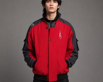 May include: A red and black jacket featuring a high collar, a front button closure, and side pockets. The jacket has dark gray sleeves with side cargo pockets and a white geometric logo on the chest. The design includes a black inner layer.