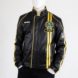 May include: Black leather jacket with yellow stripes and accents. Features the NASA logo, a "Time Travel Division" patch, and an American flag patch. The jacket has a stand-up collar and a front zipper.
