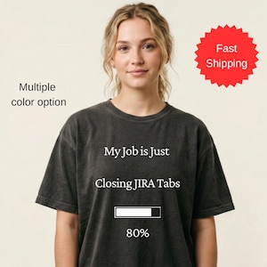 May include: Dark gray t-shirt with the text "My Job is Just Closing JIRA Tabs" and a progress bar at 80%. The shirt has a crew neck and short sleeves. The words "Multiple color option" are in the upper left corner.