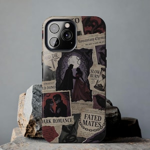 May include: A phone case featuring a collage of vintage-style newspaper clippings with a dark romance theme. The design includes images of couples, ravens, and the text "Dark Romance" and "Fated Mates". The case is on a stone surface.