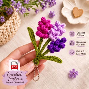 May include: A crochet pattern for a keychain featuring three hyacinth flowers in magenta, light purple, and dark purple with green stems and leaves. The design includes a metal ball chain, with text reading Crochet Pattern Instant Download.