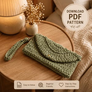 May include: A sage green crochet clutch bag with a wrist strap and a single gold-tone button closure. The item is presented as a digital download PDF pattern, featuring text that reads DOWNLOAD PDF PATTERN, Easy to follow, Beginner Friendly, and Step-by-Step Instructions.