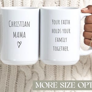 Puede incluir: Dos tazas de cerámica blancas con texto negro. Una taza dice "CHRISTIAN MAMA" con un símbolo de corazón. La otra taza dice "YOUR FAITH HOLDS YOUR FAMILY TOGETHER." Las tazas son sostenidas por manos.