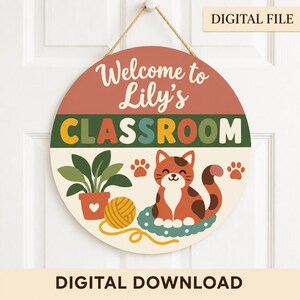 Peut inclure: Une enseigne ronde suspendue avec une corde en jute portant le texte Welcome to Lily's CLASSROOM. Le motif comprend une plante verte en pot, une pelote de laine jaune et un chat brun et blanc assis sur un tapis sarcelle avec des empreintes.