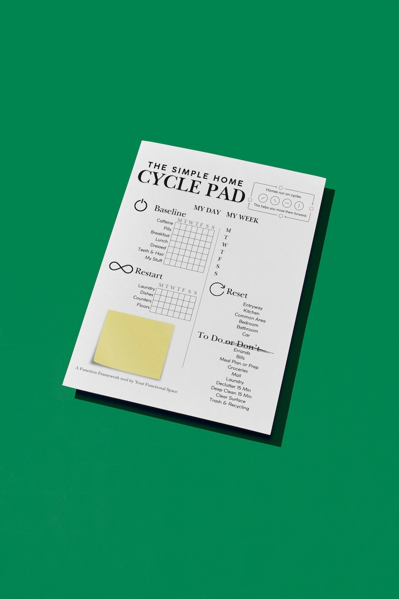 May include: A white paper pad with the text "THE SIMPLE HOME CYCLE PAD" and a yellow sticky note. The pad includes sections for daily and weekly tracking of habits and tasks, with a green background.