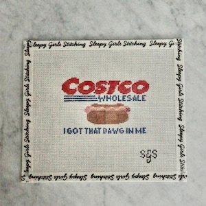 May include: Needlepoint canvas featuring the Costco Wholesale logo and a hot dog, with the phrase "I Got That Dawg In Me." The canvas is bordered with "Sleepy Girls Stitching" text.
