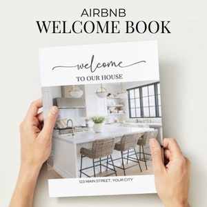 Puede incluir: Un libro de bienvenida blanco con el texto "Airbnb Welcome Book" y "Welcome to our house" en negro. El libro presenta una foto de una cocina moderna con gabinetes blancos, una encimera blanca y una campana extractora de acero inoxidable. La dirección "123 Main Street, Your City" está impresa en la parte inferior del libro.