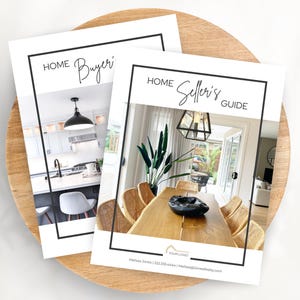 May include: Two guides, "Home Buyer's Guide" and "Home Seller's Guide", rest on a wooden tray. Each guide features a black border and a photograph of a home interior. The buyer's guide shows a kitchen, and the seller's guide shows a dining room.