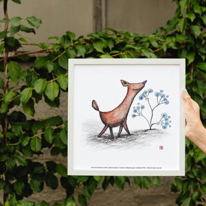 以下が含まれることがあります： 青い鼻の鹿と青い花のイラストが描かれた、額入りのアートプリント。白いフレームに入っており、緑の葉を背景にしています。可愛らしいアート作品です。