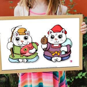 May include: A framed print featuring two cartoon cats in traditional Japanese attire. One cat holds a fishing rod and a red fish, the other holds a gold coin and a sack. The cats are white with black outlines and are set against a white background.