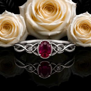 Anillo de compromiso con piedra de rubí rojo sintético de talla ovalada y diseño solitario.