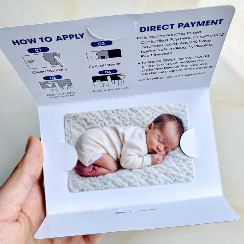 May include: A white card with instructions for direct payment, featuring a sleeping baby image. The card includes steps: clean the card, peel off the skin, align and apply, and press and smooth out. Text on the card reads "DIRECT PAYMENT".