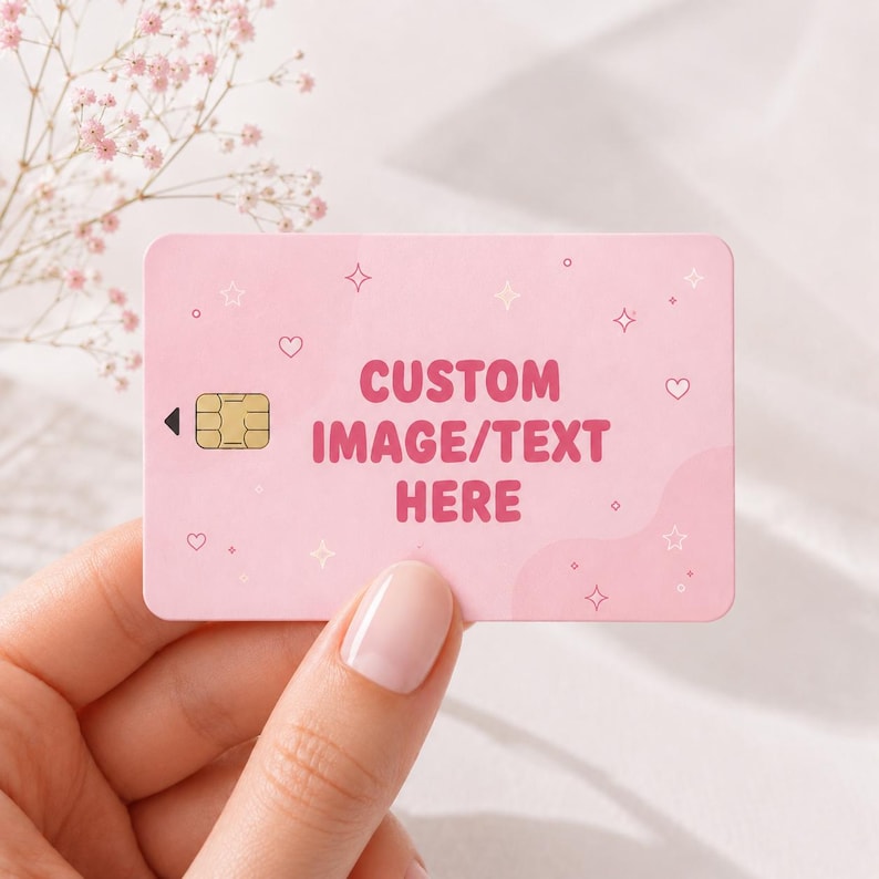Puede incluir: Una tarjeta de cr&eacute;dito rosa con el texto "CUSTOM IMAGE/TEXT HERE" en rosa intenso. La tarjeta presenta un chip dorado y est&aacute; decorada con peque&ntilde;os corazones, estrellas y brillos. La tarjeta es sostenida por una persona.