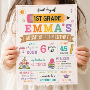 Op de afbeelding: Een wit bord voor de eerste schooldag in de 1st grade met een gele potloodafbeelding, de naam Emma en Sunshine Elementary. Het bevat secties voor datum 14 augustus 2026, leeftijd 6, lengte 114 cm, leraar Ms. Johnson, favorieten en toekomstdoelen.