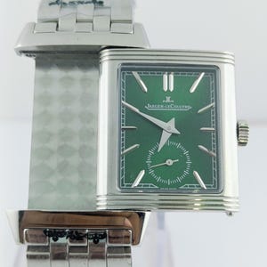 Peut inclure: Une montre Jaeger-LeCoultre argentée avec un cadran vert rectangulaire. La montre présente un petit cadran de secondes et des aiguilles argentées. Le bracelet est composé de maillons argentés.