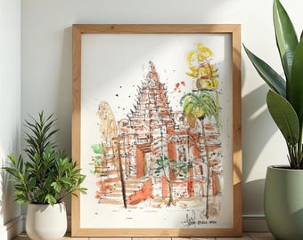 May include: Watercolor painting of a temple in a wooden frame. The artwork features a detailed depiction of the temple with orange and white tones. The painting is displayed on a wooden floor with potted plants on either side.