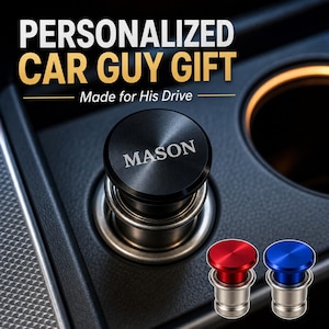 May include: A black cylindrical car cigarette lighter plug featuring the engraved name MASON on the top surface. Two additional plugs in metallic red and metallic blue are positioned in the lower right corner of the image.